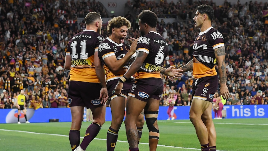 A group of rugby league players celebrate a try