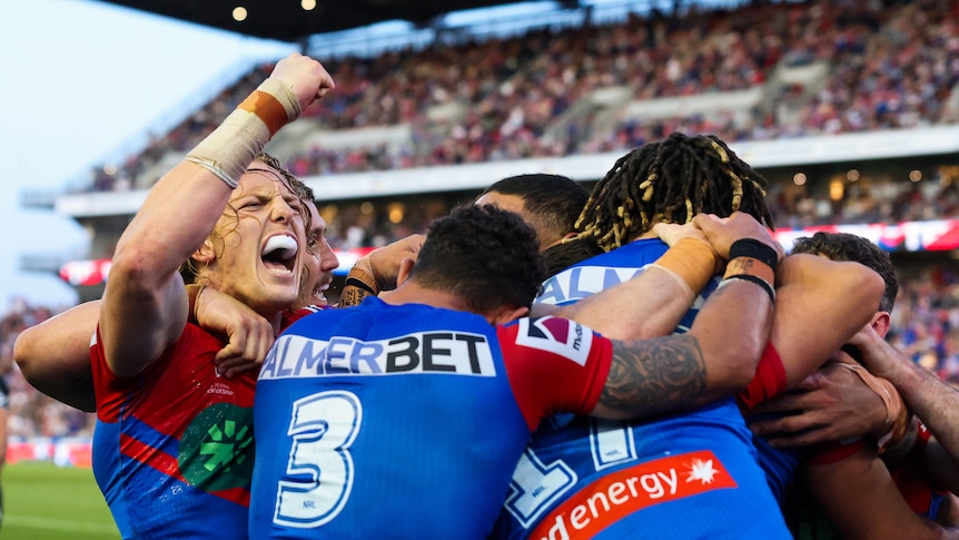 A group of rugby league players celebrate a try