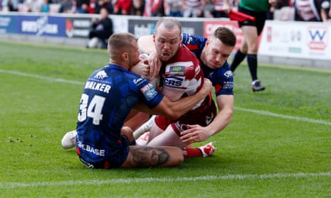 Liam Marshall fights his way over for Wigan’s first try in the playoff semi-final against Hull KR.