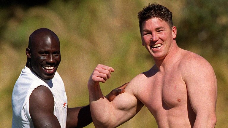 NRL great Mark Carroll showed off his muscles to former NFL player Terrell Davis in 1999. Picture: Gregg Porteous