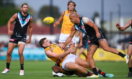 Adelaide’s Mark Keane is tackled by Port Adelaide’s Willie Rioli and Sam Powell-Pepper