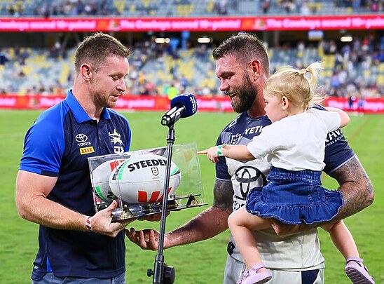 Michael Morgan presents Kyle Feldt with a match ball to commemorate scoring the most tries for the Cowboys.