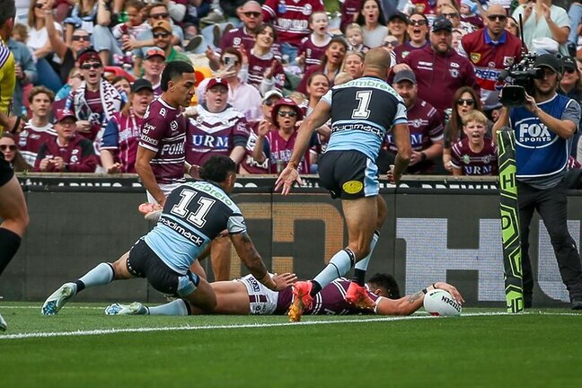 Got there...Tommy Talau crosses for his try in the corner