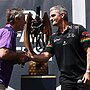 SYDNEY, AUSTRALIA - OCTOBER 03: Craig Bellamy, coach of the Storm and Ivan Cleary, coach of the Panthers shake hands alongside the Provan-Summons Trophy during NRL Grand Final Fan Fest at Overseas Passenger Terminal, on October 03, 2024, in Sydney, Australia. (Photo by Brendon Thorne/Getty Images)