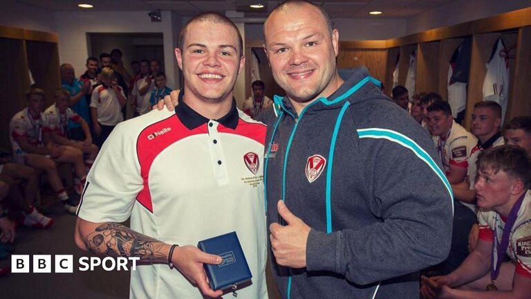 A young Jonah Cunningham stands with his dad Kieron in the changing room at St Helens