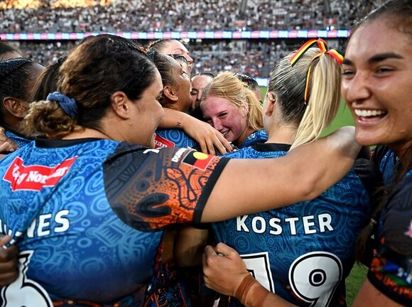 Indigenous All Stars rookies Lailani Montgomery (centre) and Ella Koster celebrate with team-mates after their 20-18 defeat of the Māori Ferns.