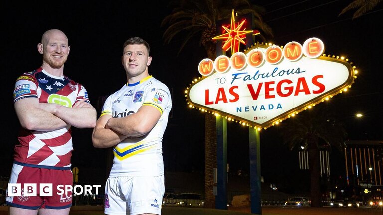 Wigan Warriors captain Liam Farrell and Warrington Wolves captain George Williams stand beside the Welcome to Fabulous Las Vegas sign