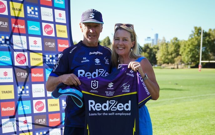 Head Coach Craig Bellamy presents Mel Woods with a personalised Storm jersey