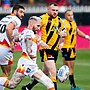 Sam Tomkins kicks the ball away as a Castleford player watches on