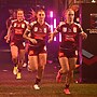 Tarryn Aiken runs out for Queensland with Julia Robinson and Lauren Brown.