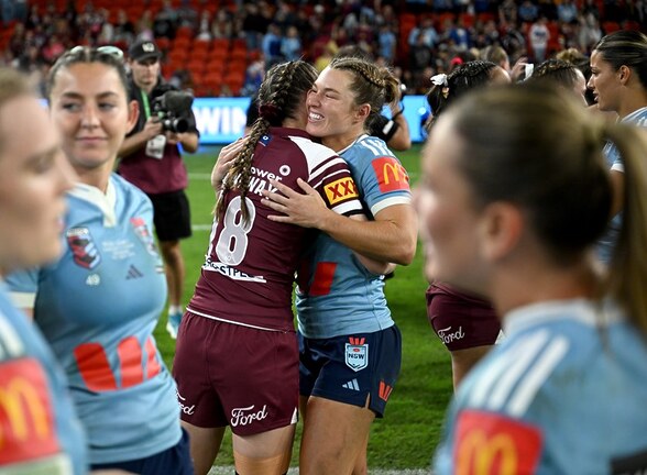 Hannaway (18th player) embraces Sharks teammate Emma Verran after game one of the women's State of Origin series.