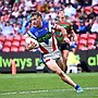 Fletcher Sharpe runs in on his way to scoring one of his three Magic Round tries.