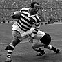 Legendary rugby league star Billy Boston (Wigan) bursts through despite a tackle by I. Watts (Hull) during the Rugby League Challenge Cup Fi