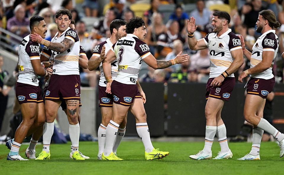 Broncos players celebrate a try against the Cowboys.