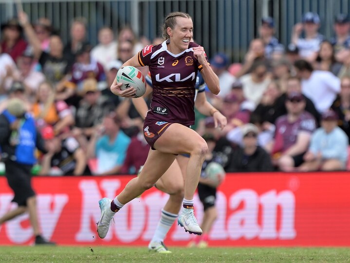 A Brisbane Broncos NRLW player tucks the ball under her arm and sprints away downfield to score.