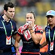 Isabelle Kelly holds a towel to her mouth after an injury in a Sydney Roosters NRLW game.