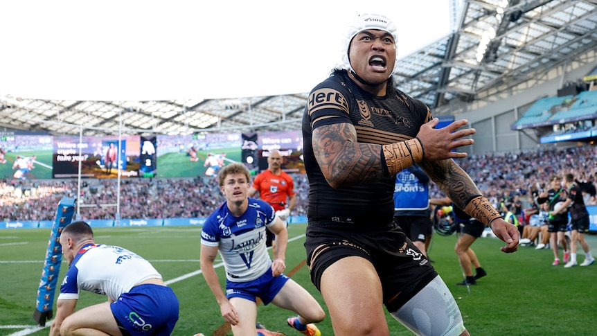 A man celebrates after scoring a try