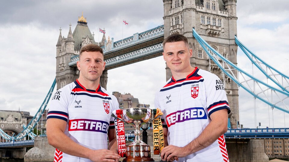 Picture by Allan McKenzie/SWpix.com - 16/07/2025 - Rugby League - ABK Beer Rugby League Ashes Series 2025 - 100 Days To Go Preview - London, England - England's George WIlliams & Jack Welsby in front of Tower Bridge with the ABK Beer Rugby League Ashes Series trophy.